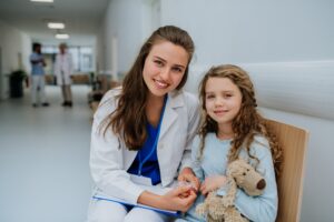 A doctor sitting with her patient, a young girl, in a hospital