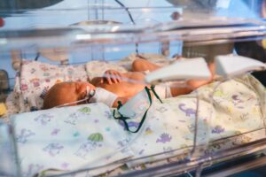 Newborn lies inside an incubator in the neonatal intensive care unit